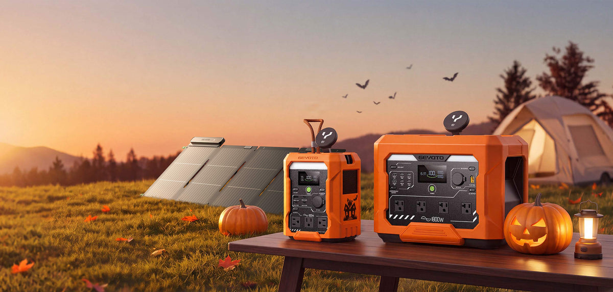 Two orange GEYOTO power stations and an unfolded solar panel beside pumpkins and a tent at sunset.