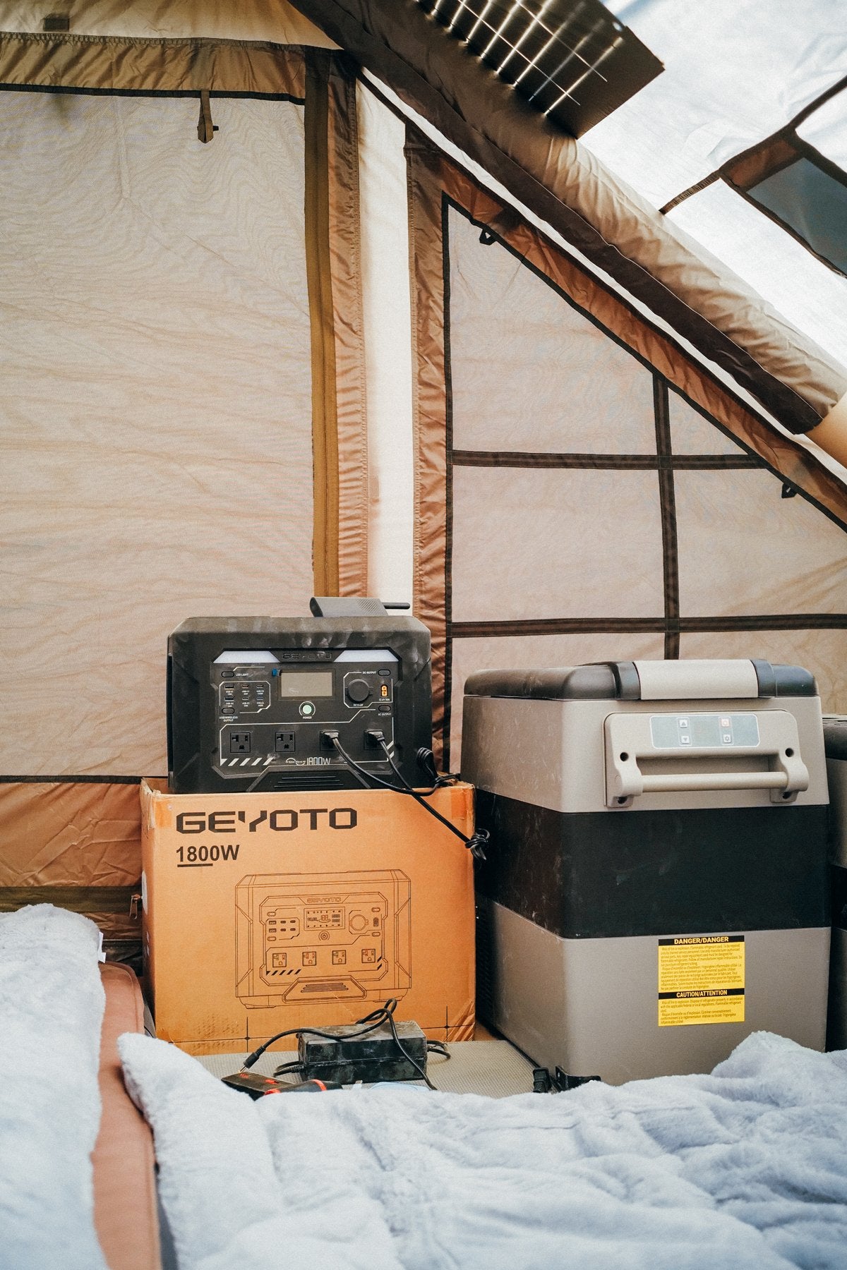 GEYOTO power station beside a portable refrigerator inside a tent